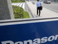 A man walks past Panasonic Corp. signage at the company's headquarters in Kadoma, Osaka Prefecture, Japan, on Wednesday, July 31, 2013. Panasonic, Japan's biggest consumer electronics maker, reported profit that exceeded analyst estimates after cutting wages, selling assets and a one-time gain from changes in pension accounting. Photographer: Tomohiro Ohsumi/Bloomberg