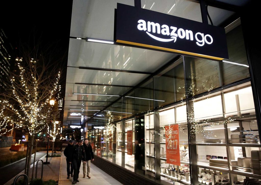 People walk by the Amazon Go brick-and-mortar grocery store without lines or checkout counters, in Seattle Washington People walk by the Amazon Go brick-and-mortar grocery store without lines or checkout counters, in Seattle Washington