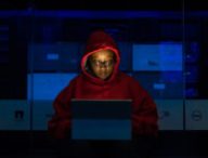 Une femme qui ne pirate probablement pas un réseau WiFi mais qui a une capuche de hackeuse. // Source : WoC In Tech