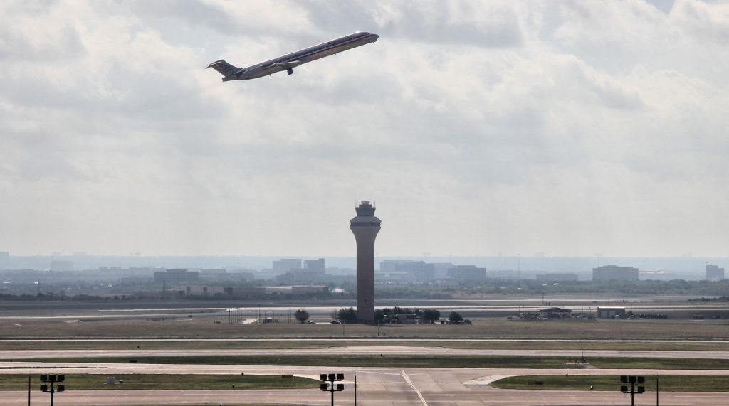 Un avion passe au-dessus d'une tour de contrôle // Source : Wikimedia Commons/Larry D. Moore