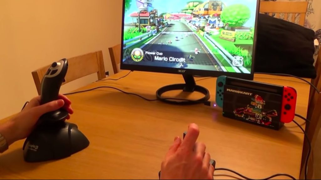 Le set up de My Mate VINCE pour Mario Kart 8 sur Switch, avec deux joysticks et la manette adaptative de Microsoft aux pieds. // Source : Youtube Le set up de My Mate VINCE pour Mario Kart 8 sur Switch, avec deux joysticks et la manette adaptative de Microsoft aux pieds. // Source : Youtube