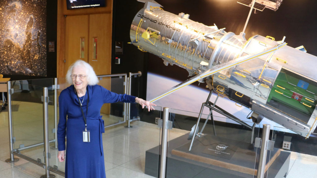Nancy Grace Roman en mars 2017 au côté d'une reproduction du télescope Hubble. // Source : Flickr/CC/Nasa Hubble Space Telescope (photo recadrée) Nancy Grace Roman en mars 2017 au côté d'une reproduction du télescope Hubble. // Source : Flickr/CC/Nasa Hubble Space Telescope (photo recadrée)