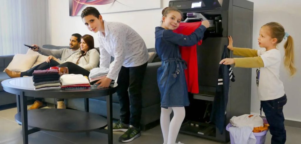 Image rare d'enfants heureux de plier des vêtements pendant que leurs parents regardent Netflix au calme. // Source : Foldimate Image rare d'enfants heureux de plier des vêtements pendant que leurs parents regardent Netflix au calme. // Source : Foldimate