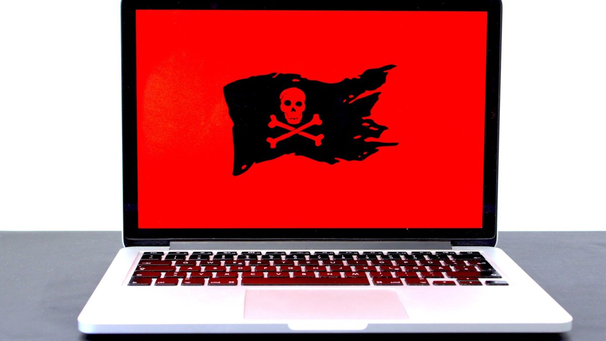 Un Macbook Pro avec un drapeau pirate rouge // Source : Michael Geiger via Unsplash Un Macbook Pro avec un drapeau pirate rouge // Source : Michael Geiger via Unsplash