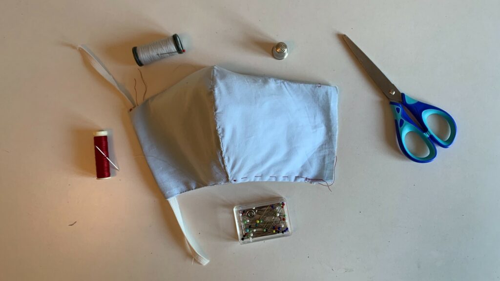 Exemple de masque en cours de réalisation, en couture à la main, à partir de coton et de feutrine. // Source : Numerama Exemple de masque en cours de réalisation, en couture à la main, à partir de coton et de feutrine. // Source : Numerama