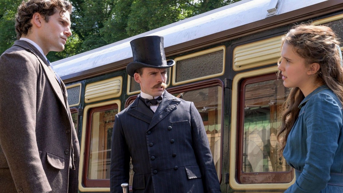 De gauche à droite : Sherlock (Henry Cavill), Mycroft (Sam Claflin) et Enola (Millie Bobby Brown). // Source : Netflix De gauche à droite : Sherlock (Henry Cavill), Mycroft (Sam Claflin) et Enola (Millie Bobby Brown). // Source : Netflix