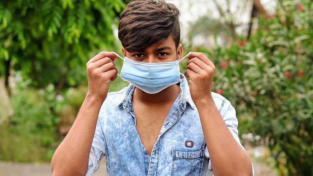 Un homme enlève un masque // Source : pikist Un homme enlève un masque // Source : pikist