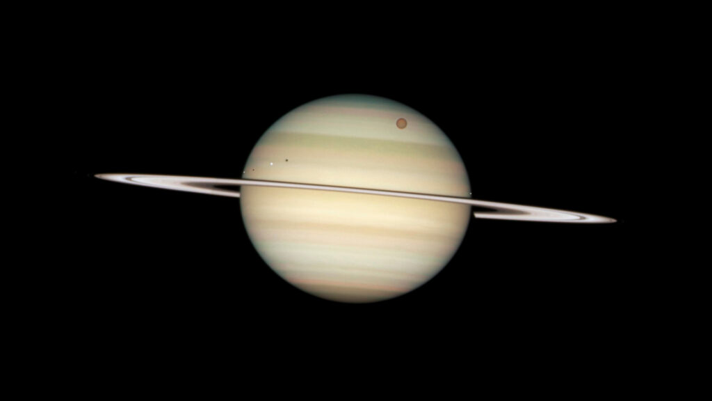 Transit des lunes Titan (la plus grosse en haut à droite) et Encelade, Dioné et Mimas (de gauche à droite, plus proches des anneaux). // Source : Flickr/CC/Nasa Hubble Space Telescope (photo recadrée) Transit des lunes Titan (la plus grosse en haut à droite) et Encelade, Dioné et Mimas (de gauche à droite, plus proches des anneaux). // Source : Flickr/CC/Nasa Hubble Space Telescope (photo recadrée)