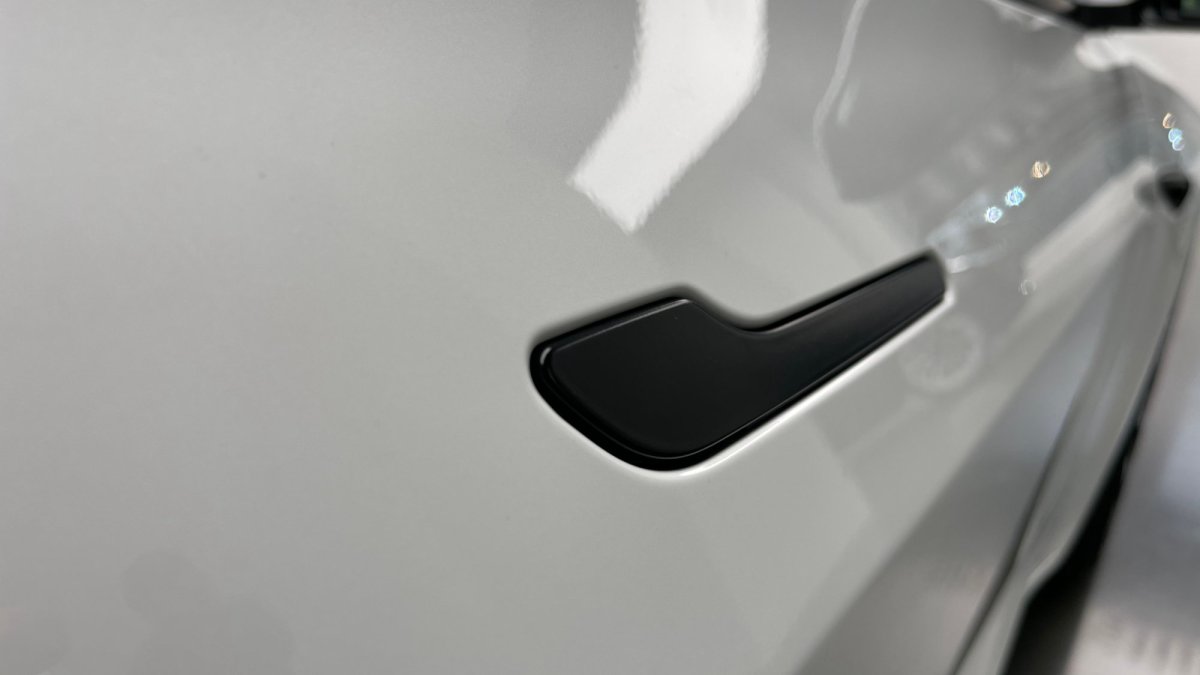 Les améliorations de la Tesla Model 3 fin 2020 : du noir à la place du chrome, mais toujours la même poignée // Source : Julien Cadot pour Numerama Les améliorations de la Tesla Model 3 fin 2020 : du noir à la place du chrome, mais toujours la même poignée // Source : Julien Cadot pour Numerama