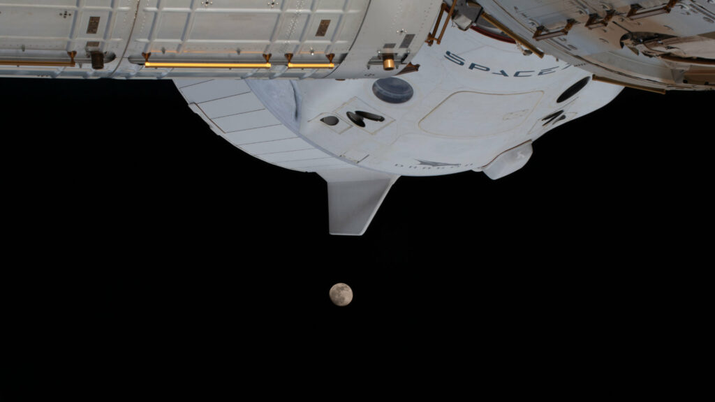 Le Crew Dragon attaché à l'ISS, et la Lune un peu plus loin. // Source : Flickr/CC/Nasa Johnson (photo recadrée) Le Crew Dragon attaché à l'ISS, et la Lune un peu plus loin. // Source : Flickr/CC/Nasa Johnson (photo recadrée)