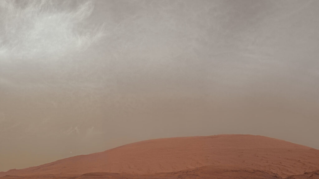 Le mont Sharp vu par Curiosity. On distingue aussi la lune Phobos. // Source : Flickr/CC/NASA/JPL-Caltech/MSSS/Kevin M. Gill (photo recadrée) Le mont Sharp vu par Curiosity. On distingue aussi la lune Phobos. // Source : Flickr/CC/NASA/JPL-Caltech/MSSS/Kevin M. Gill (photo recadrée)