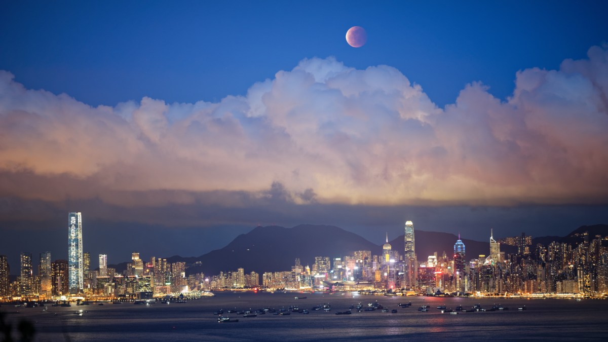 La Lune « rougit » au-dessus des nuages et des immeubles. // Source : Flickr/CC/Eddie Yip (photo recadrée) La Lune « rougit » au-dessus des nuages et des immeubles. // Source : Flickr/CC/Eddie Yip (photo recadrée)