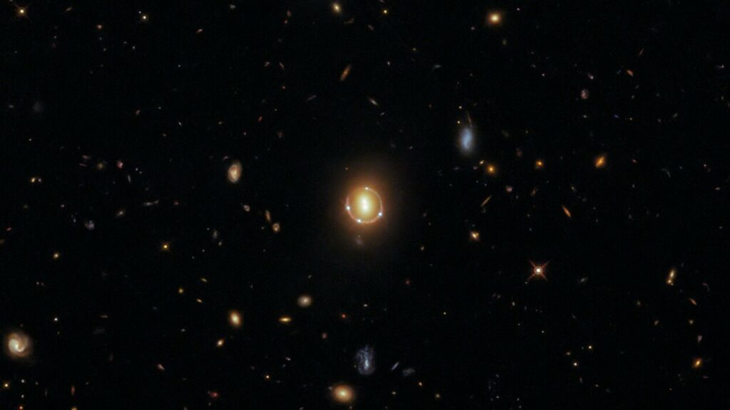 Anneau d'Einstein généré par la lumière du quasar 2M1310-1714 croisant la route de deux galaxies massives. // Source : ESA Anneau d'Einstein généré par la lumière du quasar 2M1310-1714 croisant la route de deux galaxies massives. // Source : ESA
