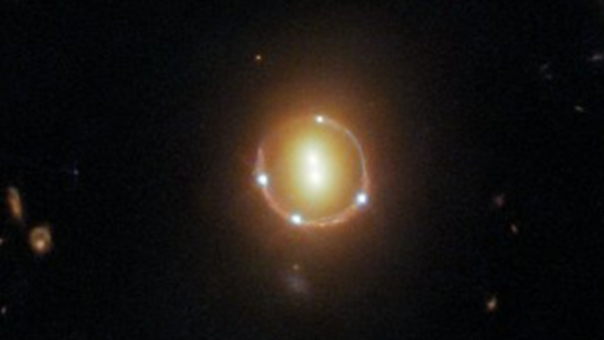 Anneau d'Einstein généré par la lumière du quasar 2M1310-1714 croisant la route de deux galaxies massives. // Source : ESA Anneau d'Einstein généré par la lumière du quasar 2M1310-1714 croisant la route de deux galaxies massives. // Source : ESA