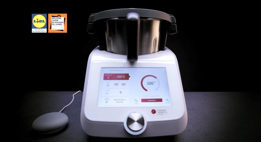 À côté du Monsieur Cuisine Smart, un Google Home Mini // Source : Lidl France À côté du Monsieur Cuisine Smart, un Google Home Mini // Source : Lidl France