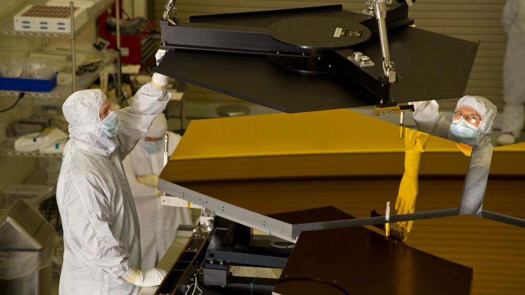 Démontage de segments du miroir après des tests, en 2011. // Source : Ball Aerospace via Flickr (photo recadrée) Démontage de segments du miroir après des tests, en 2011. // Source : Ball Aerospace via Flickr (photo recadrée)