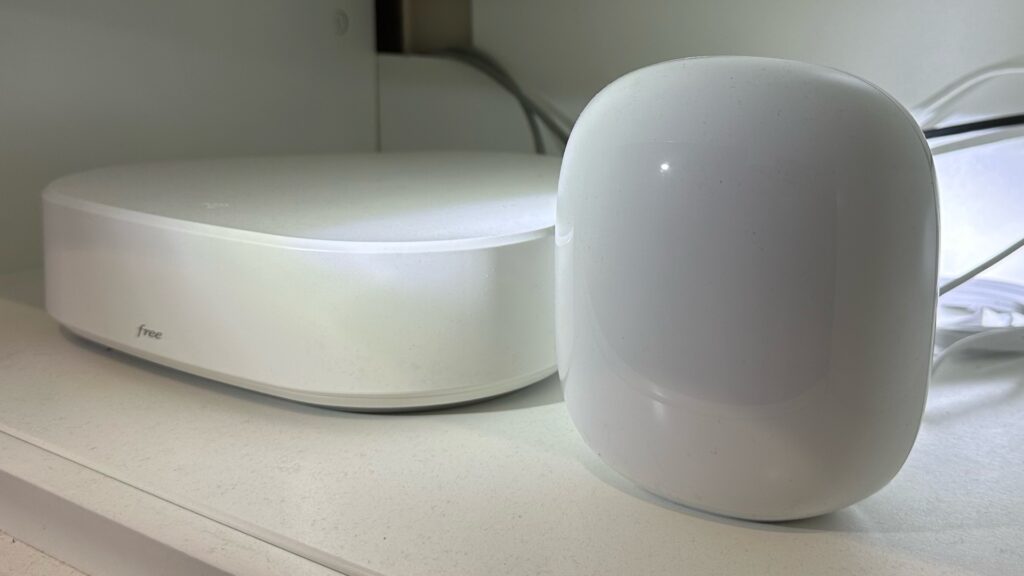 Le Google Nest Wifi Pro à côté d'une Freebox Delta, elle aussi compatible Wi-Fi 6E. // Source : Numerama Le Google Nest Wifi Pro à côté d'une Freebox Delta, elle aussi compatible Wi-Fi 6E. // Source : Numerama