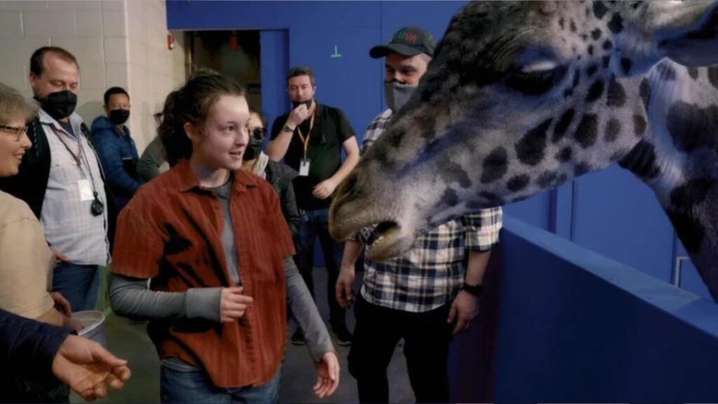 Bella Ramsey avec la girafe de The Last of Us. // Source : HBO (making of) Bella Ramsey avec la girafe de The Last of Us. // Source : HBO (making of)