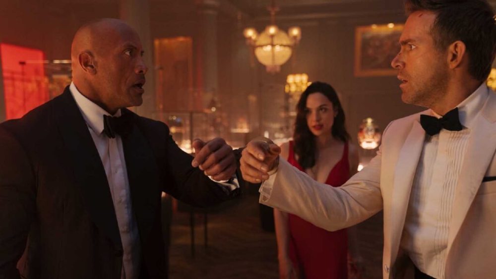 RED NOTICE - (L-R) Dwayne Johnson is the FBI’s top profiler John Hartley, Gal Gadot is the world’s most wanted art thief “The Bishop” and Ryan Reynolds is the world’s greatest art thief Nolan Booth in Netflix's RED NOTICE. Directed and written by Rawson Marshall Thurber, RED NOTICE is releasing November 12, 2021. Cr: Frank Masi / Netflix © 2021 RED NOTICE - (L-R) Dwayne Johnson is the FBI’s top profiler John Hartley, Gal Gadot is the world’s most wanted art thief “The Bishop” and Ryan Reynolds is the world’s greatest art thief Nolan Booth in Netflix's RED NOTICE. Directed and written by Rawson Marshall Thurber, RED NOTICE is releasing November 12, 2021. Cr: Frank Masi / Netflix © 2021
