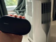 Le contrôle de clim connecté par Netatmo, à côté d'un climatiseur portable. // Source : Numerama