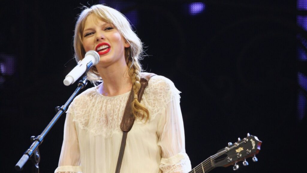 Taylor Swift en concert. // Source : Flickr/CC/Eva Rinaldi (photo recadrée et modifiée avec Canva) Taylor Swift en concert. // Source : Flickr/CC/Eva Rinaldi (photo recadrée et modifiée avec Canva)