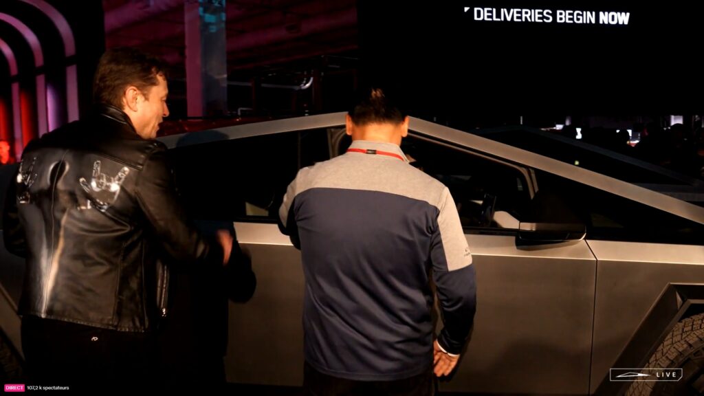 Elon Musk ouvrant les portières lors du Cybertruck delivery event // Source : Live Tesla Elon Musk ouvrant les portières lors du Cybertruck delivery event // Source : Live Tesla