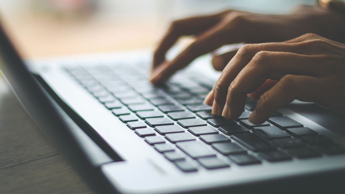 Une personne tapant sur un clavier d'ordinateur. // Source : Canva Une personne tapant sur un clavier d'ordinateur. // Source : Canva