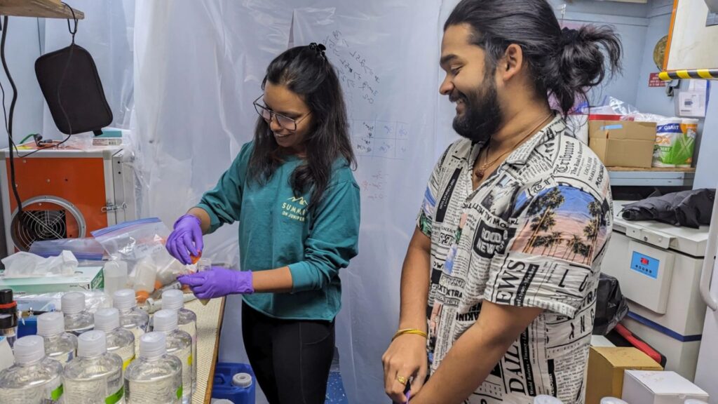 Les premiers auteurs, Diksha Sharma, à gauche, et Vignesh Menon, dirigent des expériences sur l'eau de mer recueillie dans le golfe du Maine lors d'une prolifération d'algues // Source : Annie Kandel Les premiers auteurs, Diksha Sharma, à gauche, et Vignesh Menon, dirigent des expériences sur l'eau de mer recueillie dans le golfe du Maine lors d'une prolifération d'algues // Source : Annie Kandel