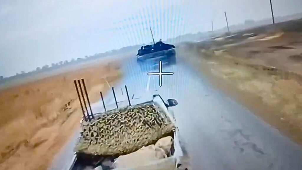 Un drone russe filoguidé continue son vol en direction du tank malgré les appareils de brouillage sur le 4x4 au premier plan. // Source : X Un drone russe filoguidé continue son vol en direction du tank malgré les appareils de brouillage sur le 4x4 au premier plan. // Source : X