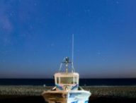 Bateau échoué sur une plage, sous un ciel étoilé. // Source : Canva Bateau échoué sur une plage, sous un ciel étoilé. // Source : Canva