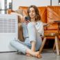 Une personne assise à côté d'un climatiseur. // Source : Envato Une personne assise à côté d'un climatiseur. // Source : Envato
