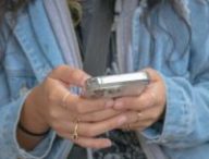 Une jeune femme avec un smartphone entre les mains // Source : Createasea via Unsplash