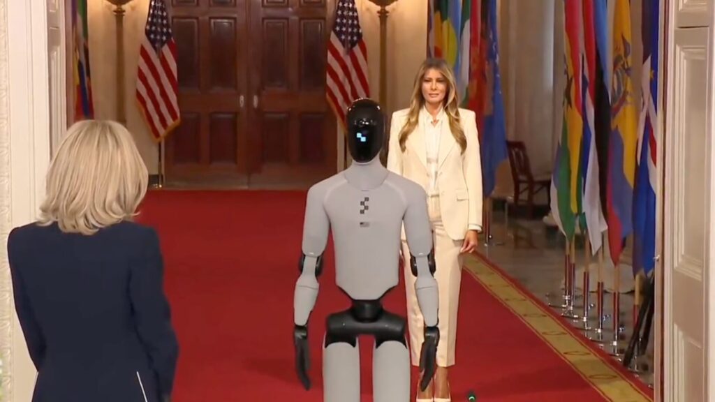 Figure 03, aux côtés de Melania Trump et Brigitte Macron. // Source : Capture d'écran Numerama Figure 03, aux côtés de Melania Trump et Brigitte Macron. // Source : Capture d'écran Numerama