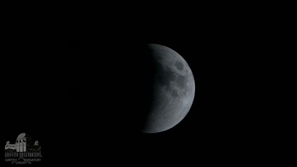 L'éclipse laisse désormais entrevoir une demi-Lune. // Source : Capture d'écran YouTube Griffith Observatory L'éclipse laisse désormais entrevoir une demi-Lune. // Source : Capture d'écran YouTube Griffith Observatory