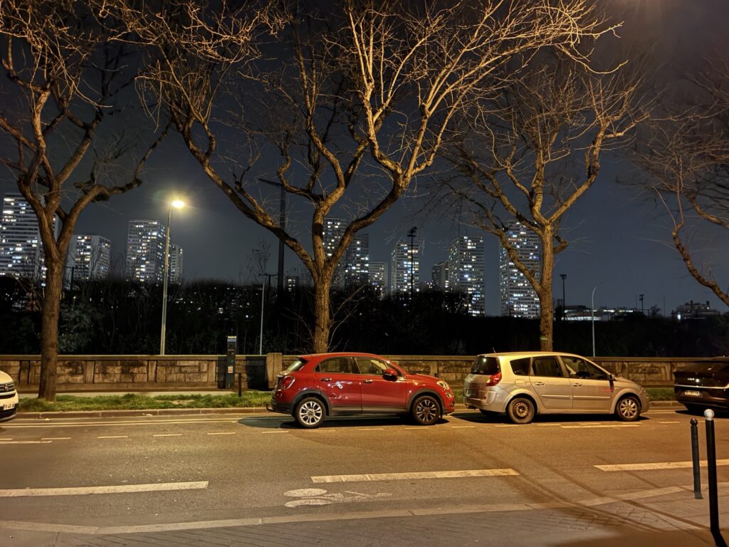 Photo de nuit prise avec l'iPhone 17e. De nombreux téléphones auraient du mal à gérer les lumières des immeubles, le téléphone d'Apple s'en sort bien. Photo de nuit prise avec l'iPhone 17e. De nombreux téléphones auraient du mal à gérer les lumières des immeubles, le téléphone d'Apple s'en sort bien.