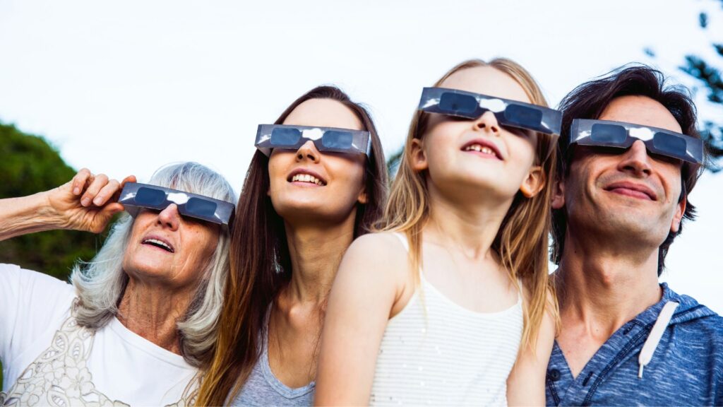 Une famille utilisant des lunettes d'éclipse. // Source : Canva Une famille utilisant des lunettes d'éclipse. // Source : Canva