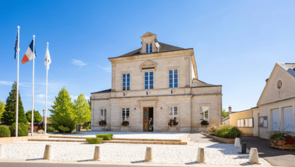 Trouver un créneau pour aller en mairie quand on travaille toute la semaine relève parfois du casse-tête. À Marolles-les-Braults, commune sarthoise d’environ 2 000 habitants, c’est précisément ce public que l’on espère mieux accompagner. « On a du mal à toucher la population active, on ne la voit pas beaucoup en mairie », explique à Numerama Jonathan Cholet, directeur général des services.  Avec l’entreprise Nouvelle Époque, la commune a développé un espace citoyen permettant de déposer un dossier d’urbanisme, de réserver une salle des fêtes ou de gérer les inscriptions à la cantine depuis son ordinateur ou son téléphone.   Elle revendique ainsi le titre de « première mairie de France ouverte 24h/24 et 7j/7 ». Une formule à comprendre au sens numérique : les agents ne passent pas leurs nuits derrière le guichet, mais les habitants peuvent engager leurs démarches sans attendre son ouverture.  Digitaliser la première mairie de France  Le projet ne répond pas, au départ, à une demande explicite des administrés. Il naît du constat que les horaires des services municipaux s’accordent mal avec ceux d’une partie de la population, et d’une rencontre sur les réseaux sociaux.  « Nouvelle Époque avait un projet de digitaliser en totalité la première mairie ou ville de France », raconte Jonathan Cholet. Son intérêt pour les nouvelles technologies et le soutien du maire font le reste. Après un premier contact fin juillet, le travail commence véritablement fin août. Deux mois plus tard, la commune dispose d’un outil commun aux habitants et aux agents.  La commune affirme avoir transposé en ligne l’ensemble des démarches proposées à son guichet, dans les limites de ce que permet la réglementation. Cela ne signifie pas que toutes peuvent être achevées à distance, ni qu’une demande déposée le dimanche sera immédiatement validée. Certains dossiers nécessitent toujours un examen par les agents et certaines formalités, une présence physique. « Demain pour se marier, il va bien falloir encore venir physiquement en mairie », ironise Jonathan Cholet.  À la cantine, deux heures de tâches administratives en moins  Pour comprendre ce que change le dispositif, il faut aussi regarder du côté des agents. La mairie indique avoir regroupé dans une seule interface des tâches auparavant réparties entre plusieurs logiciels. L’objectif est notamment d’éviter de recopier les mêmes informations d’un outil à l’autre.  L’exemple le plus concret se trouve à la cantine scolaire. Les parents peuvent désormais signaler l’absence de leur enfant jusqu’à 8 h 30 le matin. Le nombre de repas à préparer est ensuite transmis automatiquement aux équipes, avec une répartition par service et par classe. Les informations nécessaires à la comptabilité suivent le même chemin.  « On avait une responsable de cantine qui passait une heure le matin à relever les présents et les absents dans les classes, et une heure l’après-midi à transmettre à la comptabilité », rapporte Jonathan Cholet. Selon lui, ce temps peut désormais être consacré aux enfants ou à des projets axés sur le contact humain.  À l’échelle de la mairie, qui compte six personnes, le directeur général des services estime que ces automatisations permettront de dégager l’équivalent du travail d’au moins deux agents. Il s’agit d’une estimation des gains à venir, avec un impératif qu’il tient à préciser : « Il ne s’agit pas du tout de supprimer des postes. » Le temps libéré doit permettre de mieux accompagner les habitants, notamment les familles en deuil ou les personnes qui constituent un dossier d’urbanisme.  Cette transformation passe aussi par des agents qui ont connu plusieurs générations d’outils. Jonathan Cholet prend l'exemple d'Isabelle, qui a « connu la machine à écrire ». À deux ans de la retraite, elle propose d’elle-même des améliorations pour la plateforme, raconte-t-il : « Ça balaie un peu les préjugés. » Pour le directeur général des services, l’âge des équipes ne saurait être un frein à la modernisation.  L’intelligence artificielle, elle, occupe une place très mesurée. Selon la collectivité et Nouvelle Époque, elle intervient uniquement via un chatbot propulsé par les modèles français de Mistral AI pour répondre aux questions basiques des usagers. Pour le reste, il s’agit d’automatisation classique de flux et de génération documentaire.  L’inspiration Apple : fermer l’écosystème pour verrouiller les données  Sur le volet technique, Nouvelle Époque assume une approche radicale : bâtir un environnement hermétique. Avant cette refonte, le site municipal tournait sous WordPress, une plateforme jugée trop exposée aux attaques automatisées. L’entreprise a donc développé son propre code propriétaire modulaire, déployé sur un serveur dédié par collectivité et hébergé chez OVH en France.   « On a imaginé l’écosystème d’Apple, où la marque a un système fermé, protégé et maîtrise toute la chaîne », détaille Alison Tartary, directrice générale de Nouvelle Époque. Pour pousser cette logique d'isolation, la société indique avoir banni Microsoft 365 ainsi que les solutions tierces non française, et prévoit même de déployer prochainement un système d'exploitation propriétaire sur mesure pour verrouiller les postes de travail municipaux. Il ne s'agit pas d'une condition pour bénéficier de leurs services, mais cela est encouragé par l'entreprise.  Selon celle-ci, la réduction de la surface d'attaque passe également par la suppression des comptes locaux : la mairie ne stocke ni identifiants ni mots de passe. L'authentification citoyenne repose exclusivement sur FranceConnect, tandis que les agents utilisent ProConnect. « Les données appartiennent à la mairie, les logiciels qu’on fait appartiennent à la mairie », martèle Alison Tartary, rappelant que chaque serveur dispose d'une sauvegarde et d'une machine de secours en cas d'incident. Si ce cloisonnement élimine de nombreuses failles courantes, un code fermé conçu par une structure restreinte ne garantit pas pour autant une inviolabilité absolue.   Côté budget, la commune rémunère la prestation sous la forme d’un abonnement annuel. Jonathan Cholet assure que la résiliation des huit contrats antérieurs compensera largement la facture. Les montants précis n’ayant pas été communiqués, il reste toutefois impossible de chiffrer l’économie nette réalisée à ce stade.  Le guichet reste ouvert, lui aussi  Reste l'enjeu de la fracture numérique : que deviennent les administrés réfractaires aux écrans ou dépourvus de connexion ? Jonathan Cholet insiste sur le maintien de l’accueil physique.  Pour éviter les décrochages, la commune a installé une grande tablette tactile munie d'un clavier à l'accueil de la mairie. Les usagers en difficulté y sont guidés par un agent. « On ne fait pas à leur place », souligne le responsable territorial. L'objectif est d'accompagner l'apprentissage pour rendre l'administré autonome sur d'autres portails publics, comme Ameli ou les impôts.  Marolles-les-Braults espère désormais faire figure d'exemple auprès d'autres collectivités. L’expérimentation montre qu'une petite commune peut revoir ses processus informatiques de fond en comble, à condition d'accompagner les agents comme les citoyens dans la transition. Nouvelle Époque indique de son côté être en contact avec « 5 à 6 » communes souhaitant franchir le cap d'ici la fin d'année. // Source : Jonathan Cholet